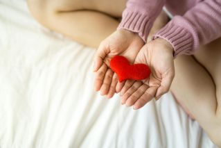 Crop woman with heart on palms